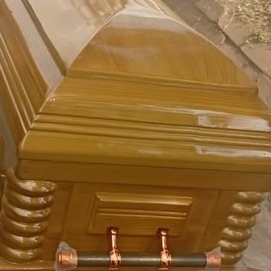 Close-up of a gold-finish casket with detailed fittings