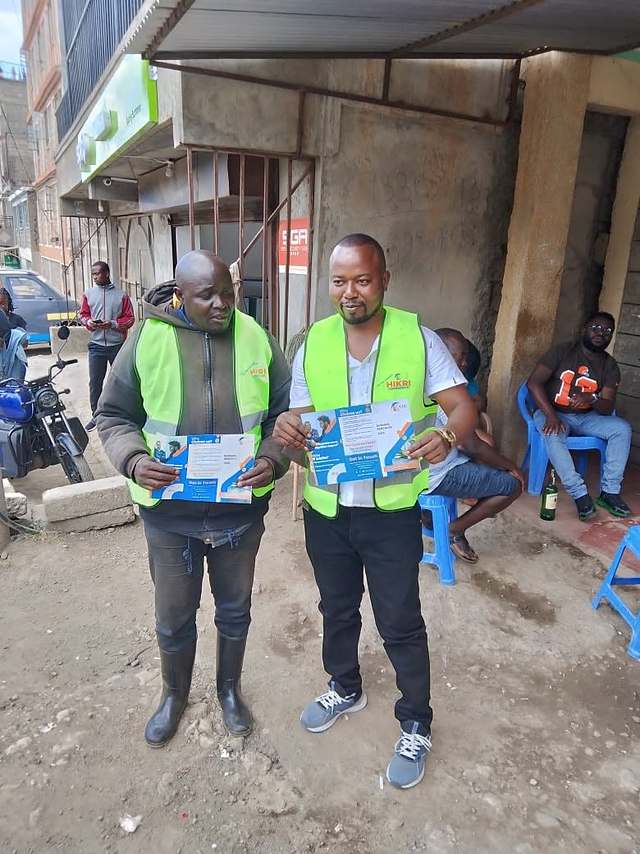 Hikri Companion field agents in branded vests holding plan brochures