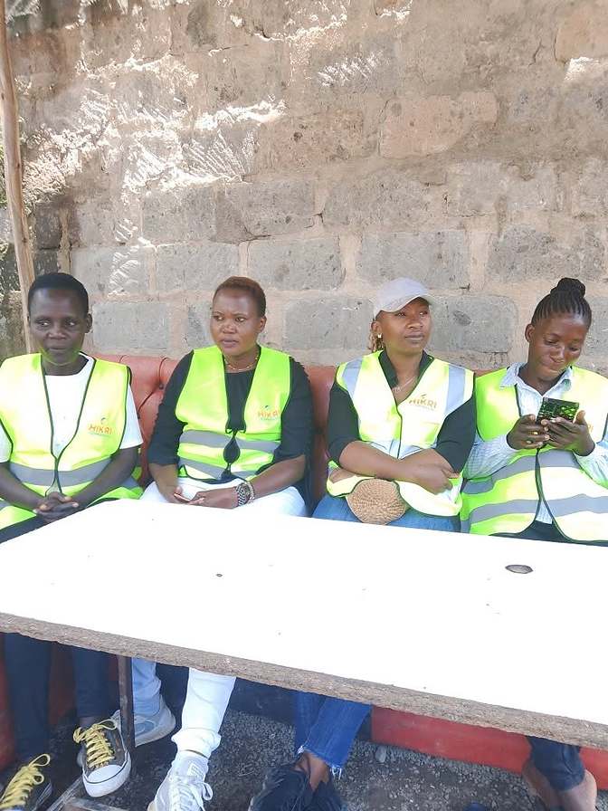Hikri Companion field agents in branded vests at a community session